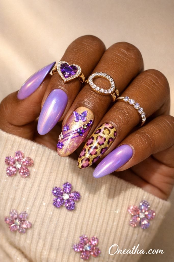 Purple butterfly nails with lilac chrome finish, gold and purple glitter accents, leopard print nail design, rhinestones, and glossy stiletto acrylic nails on a warm-toned hand with gold rings, luxury nail inspiration