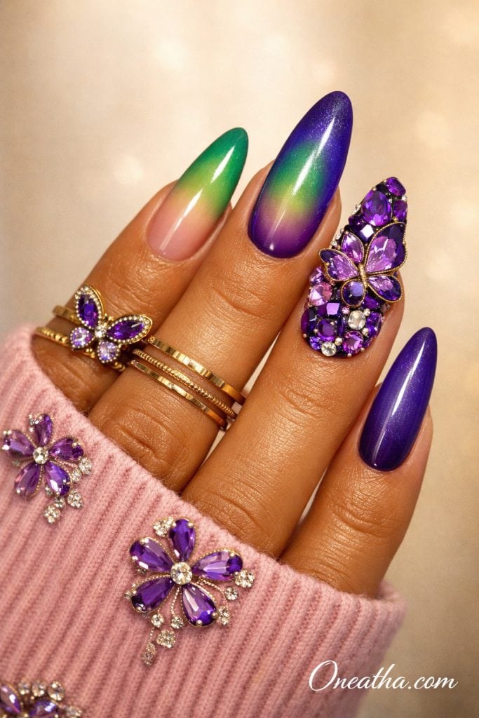 Purple butterfly nails with chrome finish, rainbow ombre accent nail, 3D gemstone butterfly design, rhinestones, and glossy almond acrylic nails on a warm-toned hand with gold rings, luxury nail inspiration