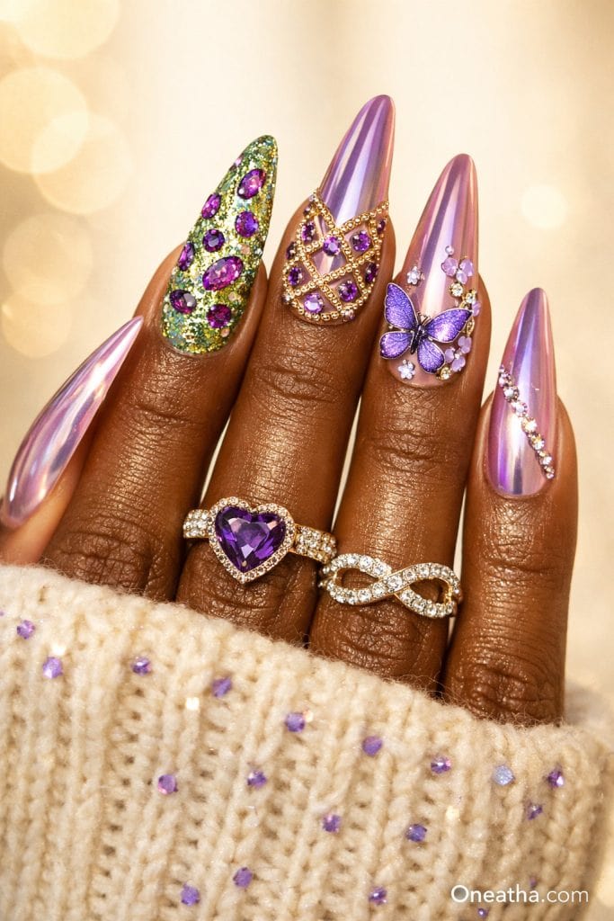 Purple butterfly nails with chrome lilac finish, gemstone accent nail, gold detailing, rhinestone accents, glossy stiletto acrylic nails, luxury nail design on warm-toned hand with gold rings