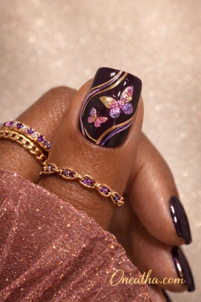 Dark purple butterfly nails with glossy plum base, glitter butterfly nail art, gold swirl detailing, short square acrylic nails, luxury nail design on warm-toned hand with gold rings