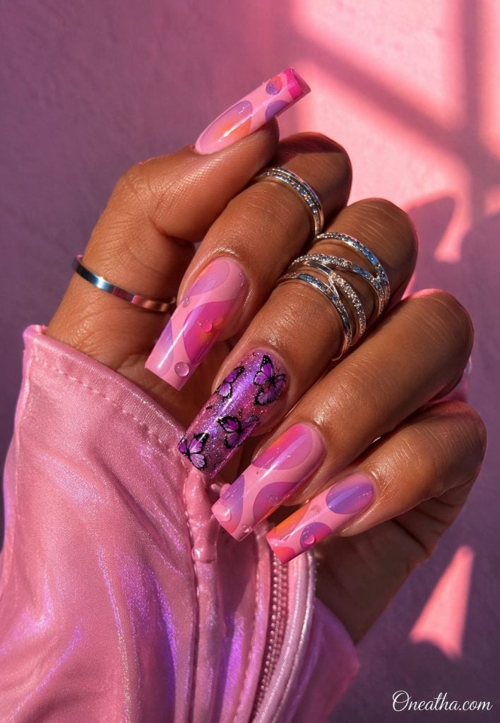 Glossy pink butterfly nails with a purple sparkle accent nail.