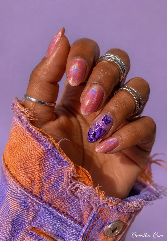 Pink chrome nails with a purple butterfly accent nail.