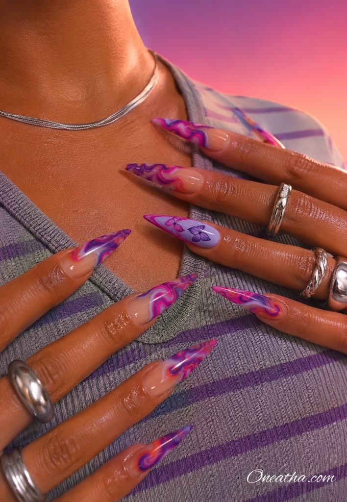Purple butterfly swirl stiletto nails.