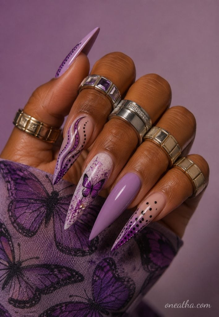 Lavender butterfly stiletto nails with glitter accents.