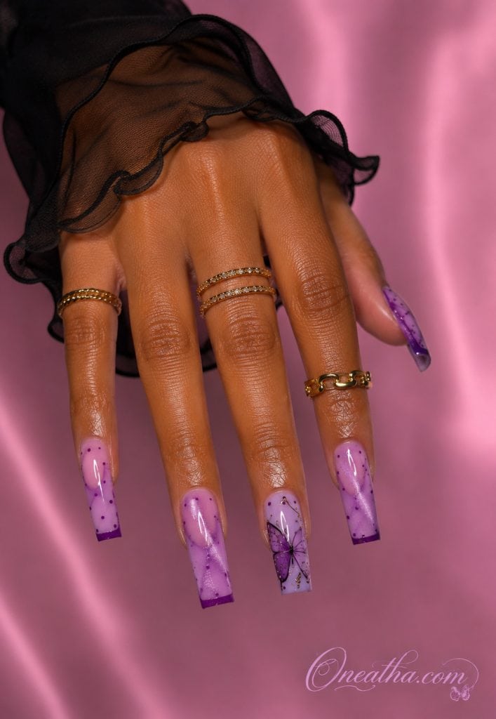Glossy lilac cat-eye nails with purple butterfly art and polka dot details.
