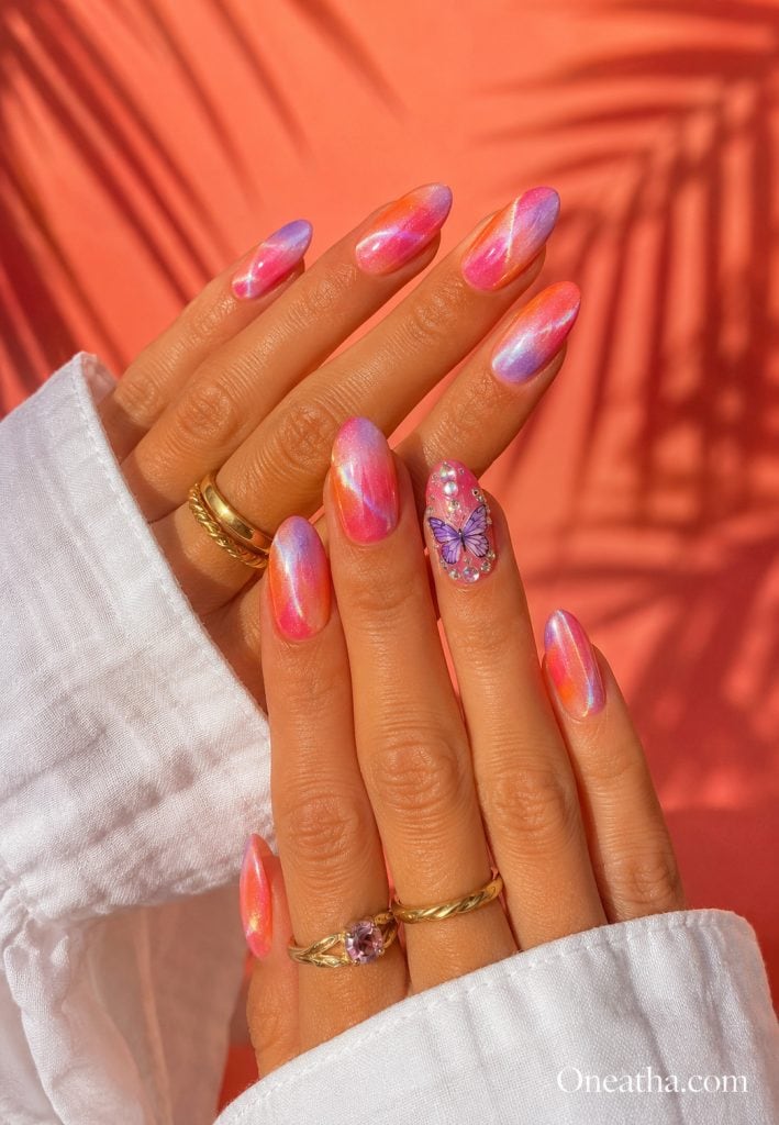 Purple-orange aura nails with a butterfly accent nail.
