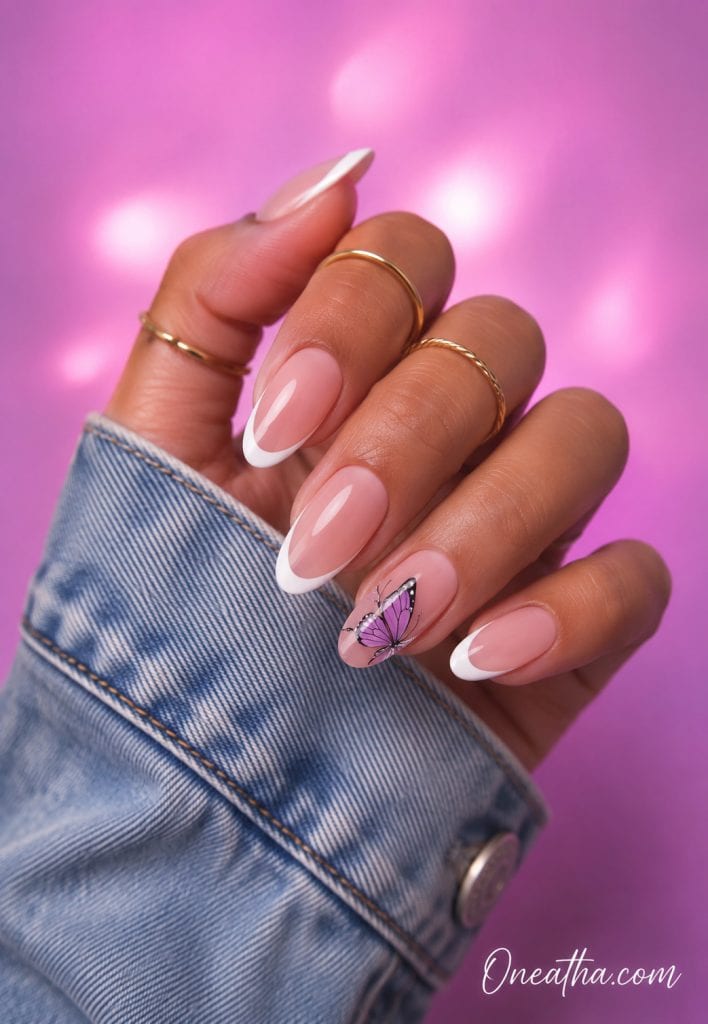 Oneatha almond french tip nails with a purple butterfly accent.