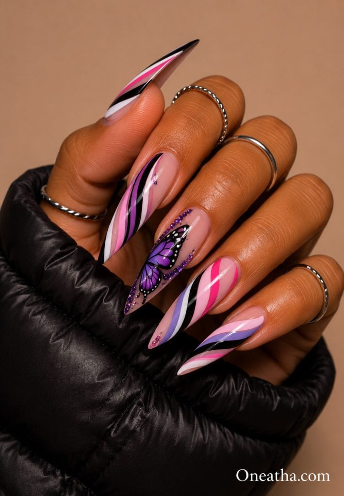 Purple butterfly striped stiletto nails with rhinestone accent.