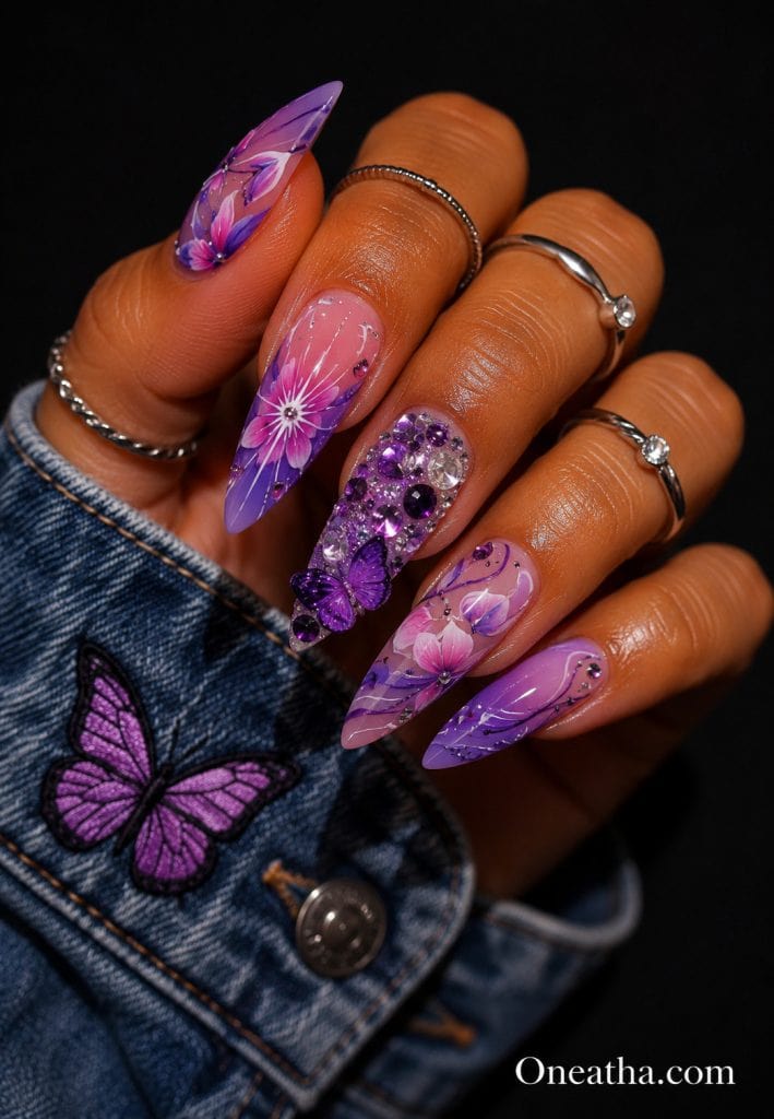 Pink and purple floral butterfly nails with sparkling gemstone accent.