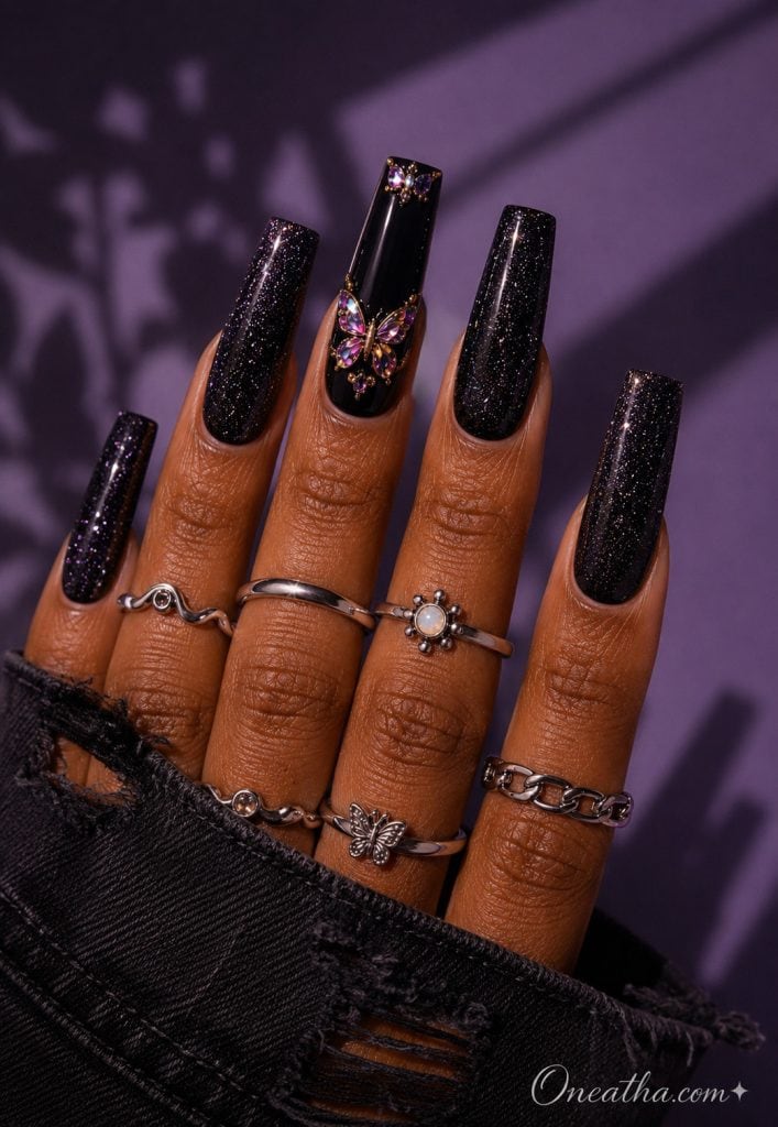 Glossy black coffin nails with jeweled butterfly accent nail.