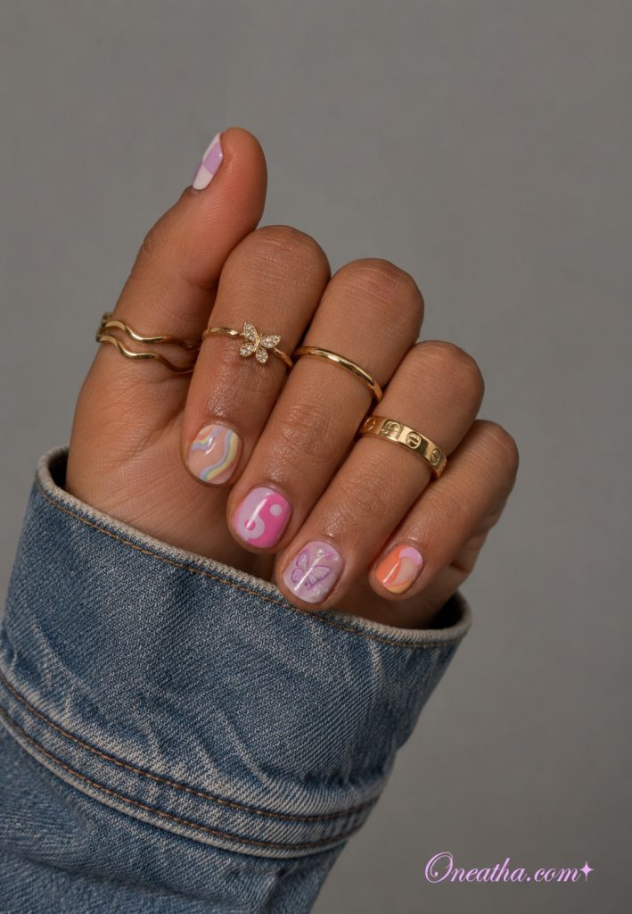 Short pastel nails with a pearly purple butterfly accent nail.
