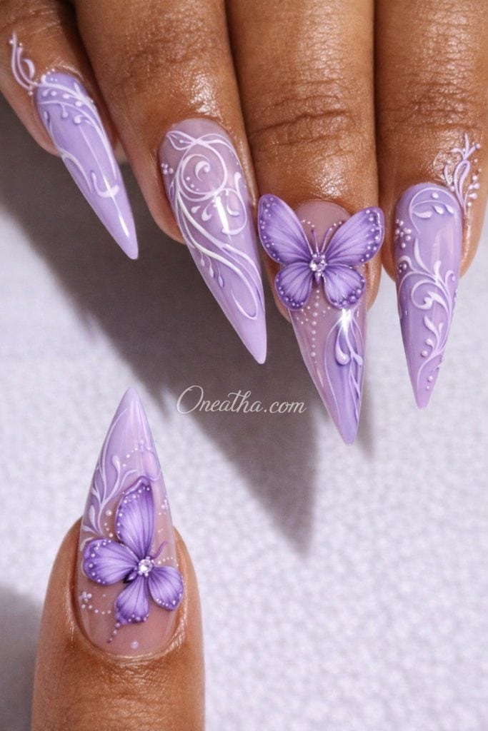 Stiletto butterfly nails with lilac swirl nail art and soft chrome finish featuring elegant butterfly designs on luxury long nails, butterfly nail design aesthetic, lilac butterfly nails, chrome stiletto nails by Oneatha, luxury nail art inspiration Oneatha Nails, summer butterfly nails design.