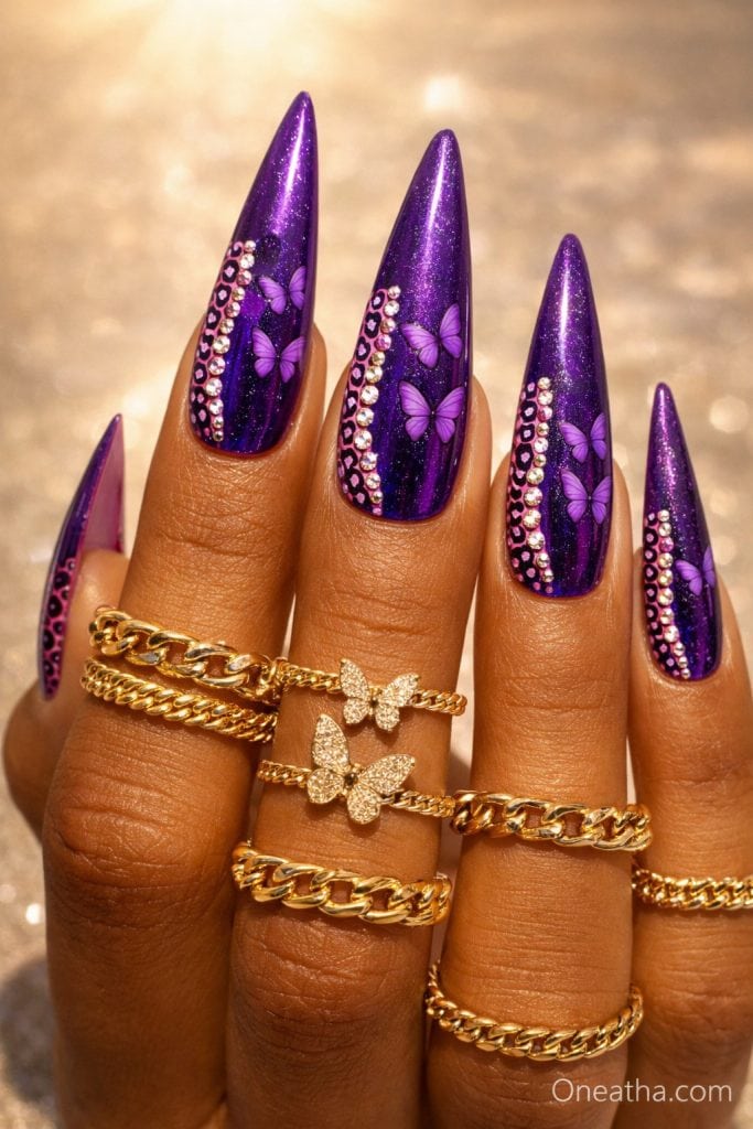 Oneatha Luxe deep purple chrome stiletto nails with purple butterfly nail art, rhinestones, leopard print accents, and luxury purple nail inspiration.