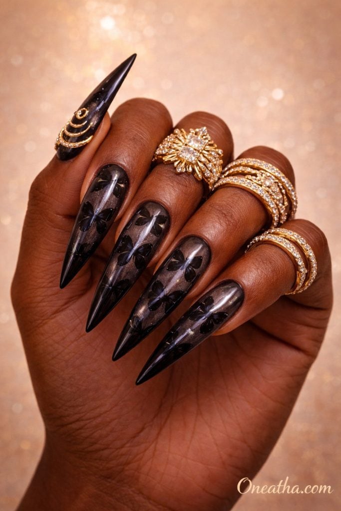 Black glass butterfly nails with embedded butterfly decals on long stiletto nails with a high-shine finish. Elegant black butterfly nail design with a glossy, translucent effect and luxury detailing.