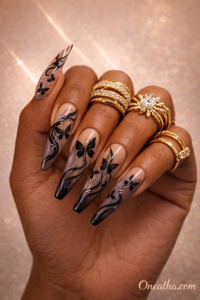 Coffin-shaped nails with black butterfly designs, abstract line art, and micro crystal accents on a glossy neutral base. Elegant butterfly nail design with soft detailing, subtle sparkle, and a luxe finish.