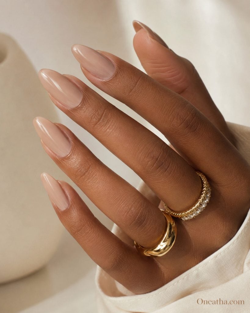 Glossy nude almond nails with luxury finish styled by Oneatha showcasing timeless neutral beauty for date night and elegant evening looks.