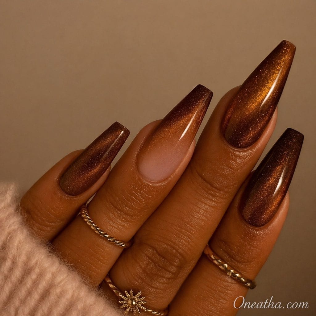 Brown shimmering “Ember Love” nails by Oneatha with glossy finish and elegant sculpted nail shape.