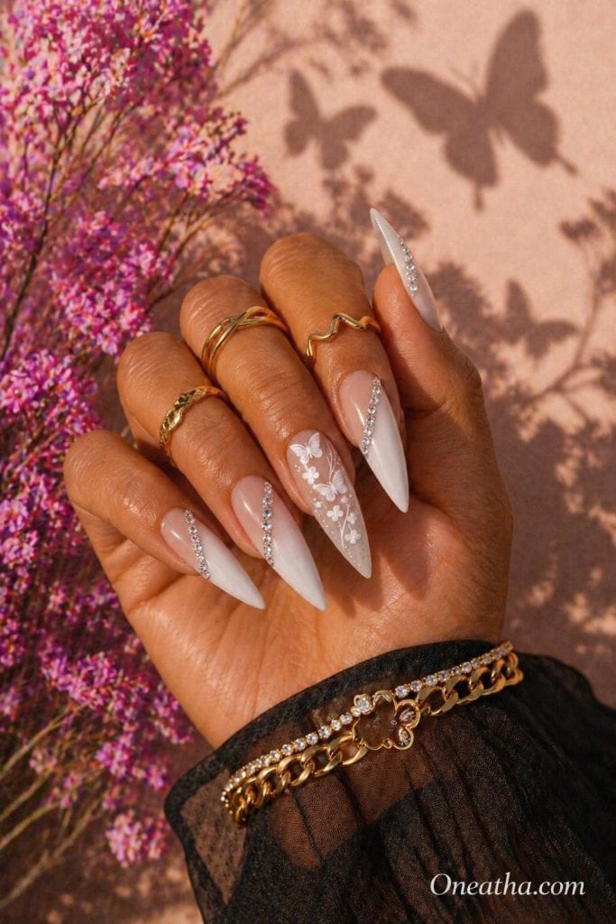 Summer butterfly nail designs by Oneatha featuring luxury rhinestone accents across elegant nails, gemstone-inspired detailing, and a high-end butterfly nail aesthetic perfect for summer beauty inspiration.