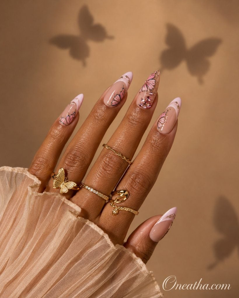 Nails by Oneatha featuring butterfly French tip nail designs with soft pink tips, almond-shaped nails, and a delicate feminine aesthetic inspired by elegant butterfly nail artistry.