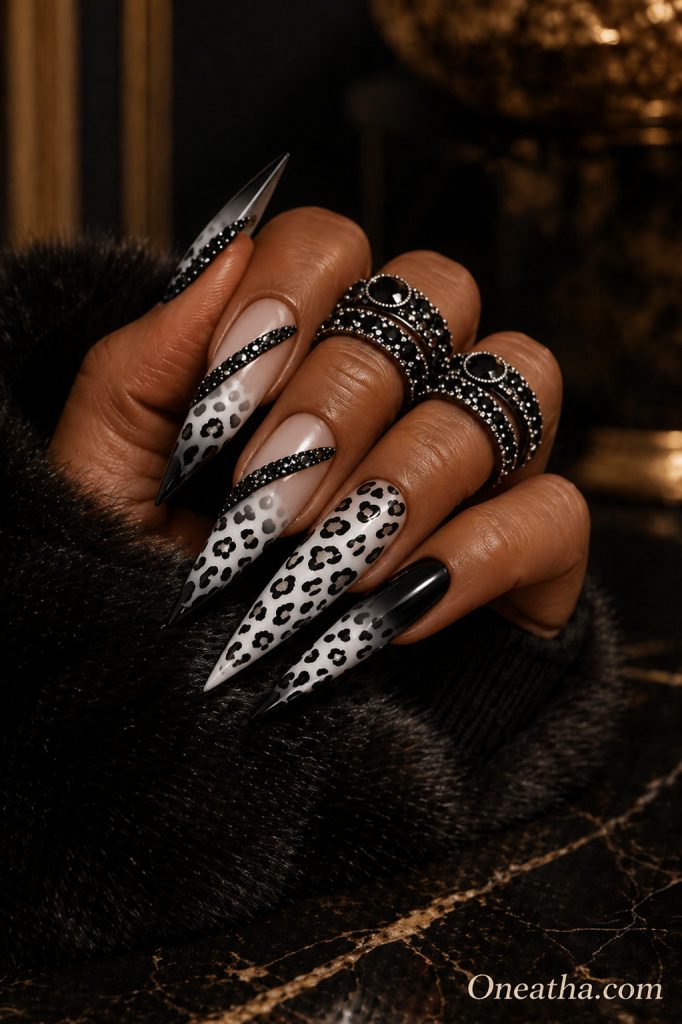 Leopard nails by Oneatha featuring black and white leopard print, glossy black nail designs, sparkling black gemstones, and a bold luxury manicure with an edgy feminine aesthetic.