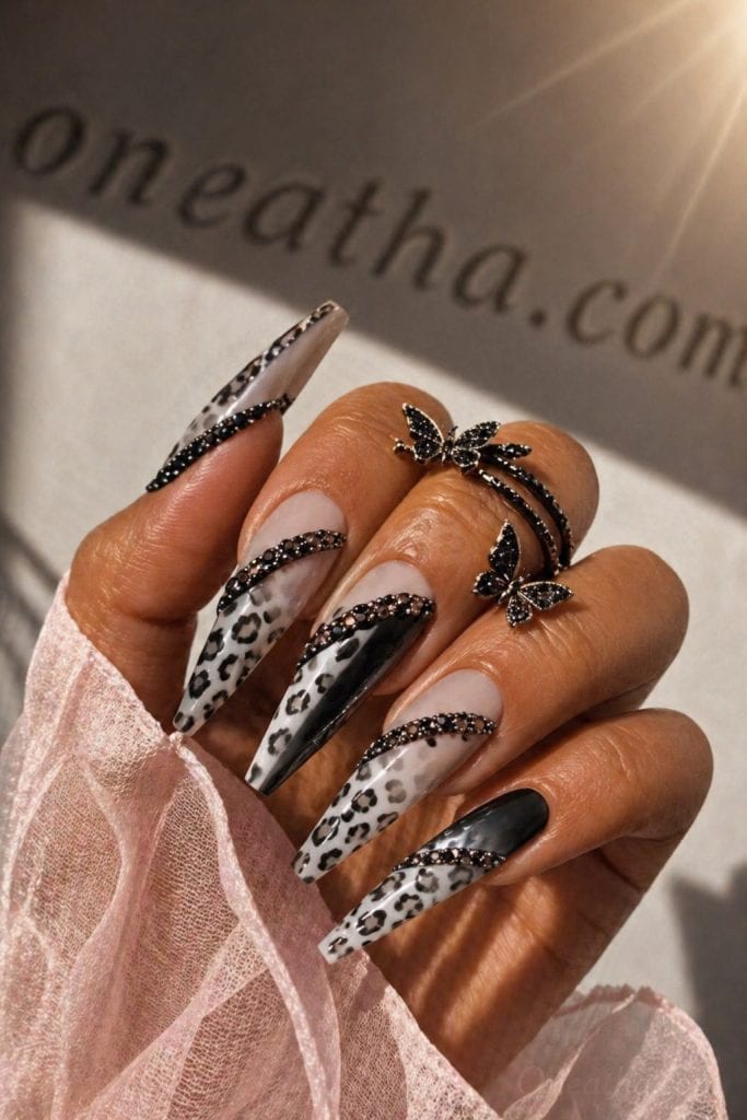 Leopard black nail designs by Oneatha featuring extra long stiletto acrylic nails with black ombré fading into leopard print and a glossy black accent strip design.