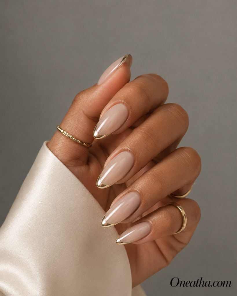 Luxury nail designs by Oneatha featuring elegant champagne chrome French tip nails with a glossy finish. This sophisticated manicure is perfect for New Year's Eve, weddings, parties, and other special occasions.