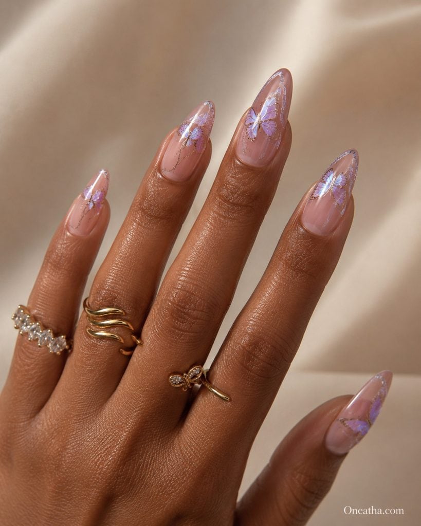 Luxury purple butterfly nails by Oneatha featuring long glossy almond nails with intricate lavender butterfly nail art, creating an elegant, feminine, fantasy-inspired summer manicure.