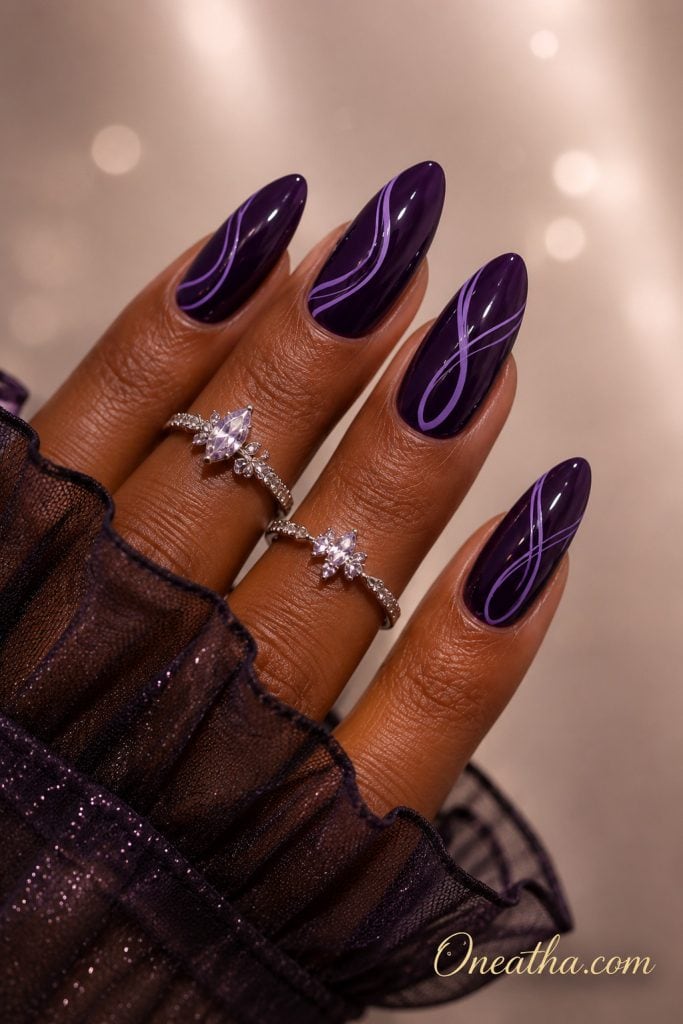 Purple glossy nail designs by Oneatha featuring deep glossy almond nails with elegant lilac purple swirl nail art and a luxury editorial aesthetic.